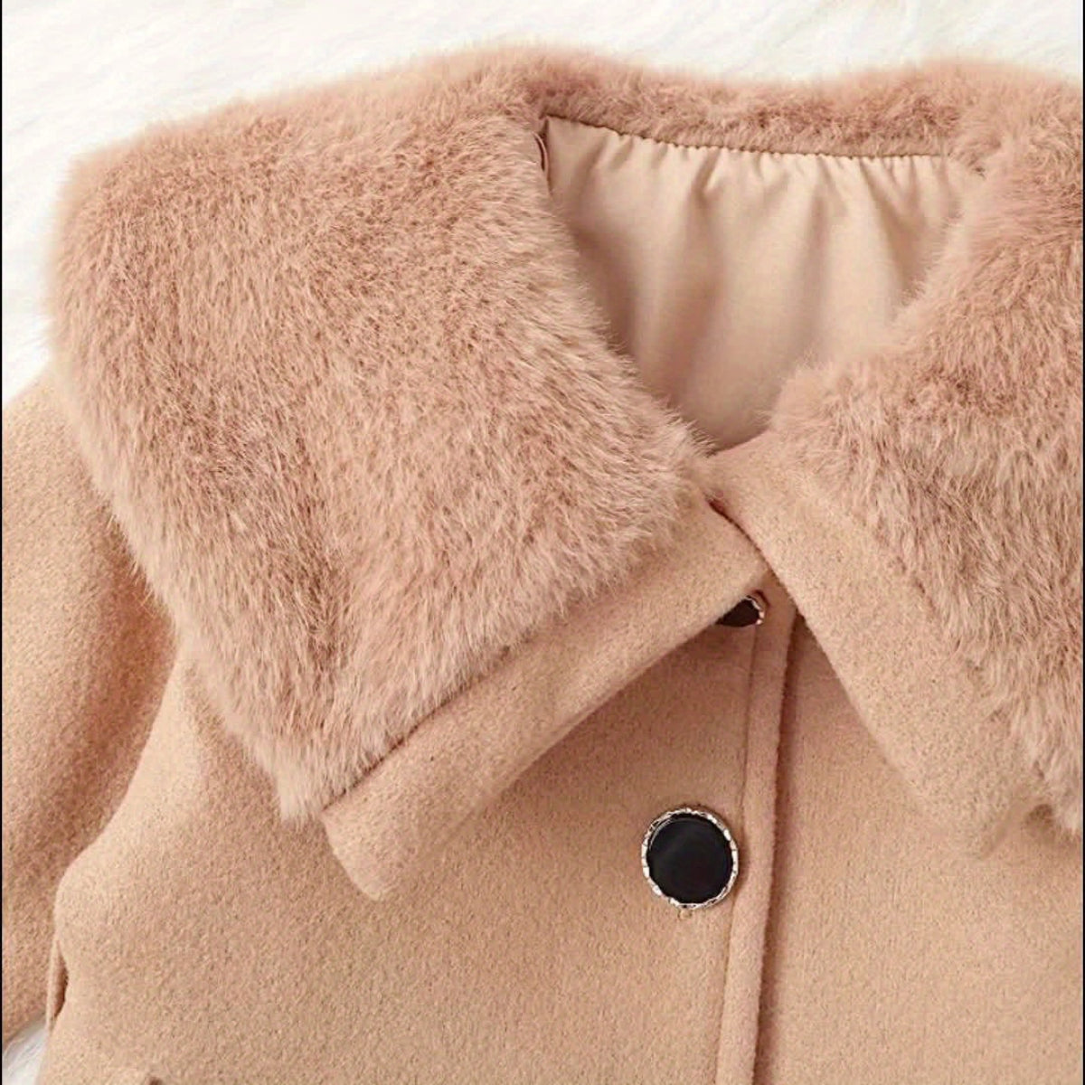Keep your baby girl warm and stylish with our Winter Coat featuring a plush collar and bow. Perfect for chilly days.